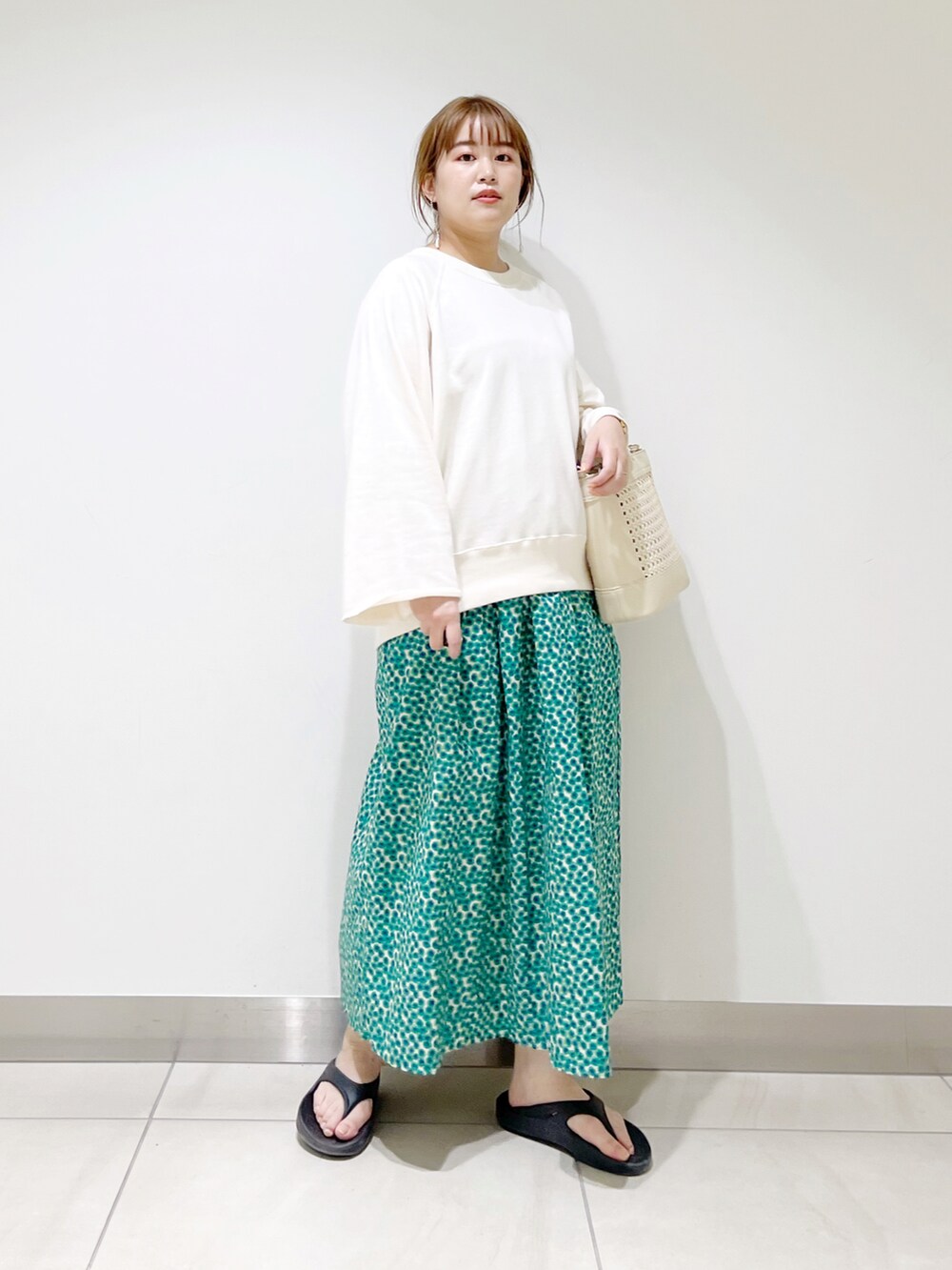 ホワイト系のTシャツ/カットソー、グリーン系のスカート、ホワイト系のバッグを着用したレディースの春コーディネートの4枚目の写真