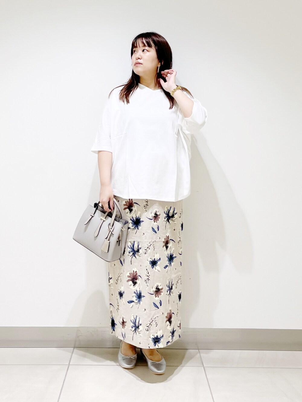 ホワイト系のTシャツ/カットソー、グレー系のトートバッグ、ブルー系のスカートを着用したレディースの夏コーディネートの3枚目の写真