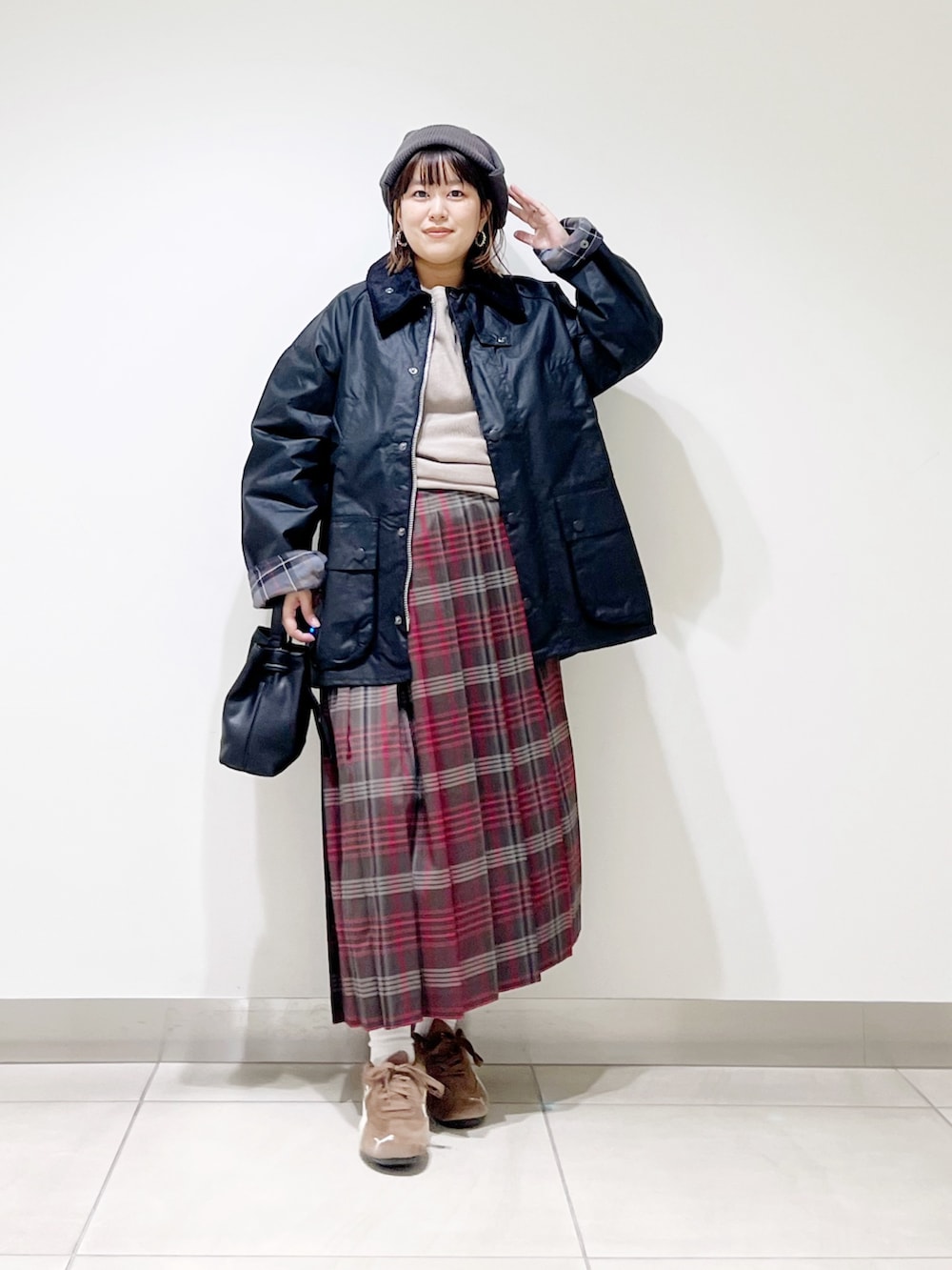 ブラック系のテーラードジャケット、グレー系のTシャツ/カットソー、ブラウン系のスカートを着用したレディースの秋コーディネートの5枚目の写真