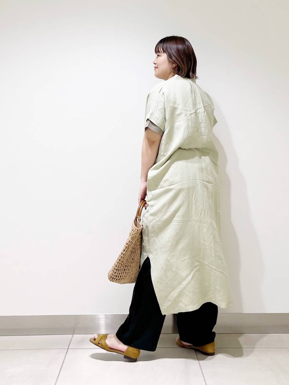 ブラック系のその他パンツ、グリーン系のワンピース、ベージュ系のトートバッグを着用したレディースの春コーディネートの5枚目の写真