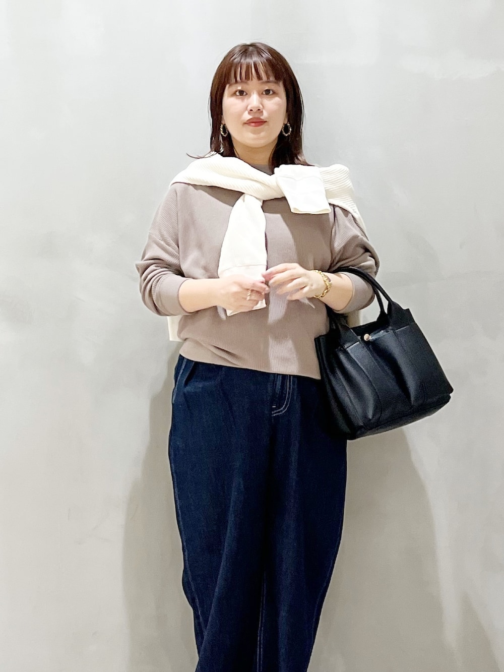 グレー系のTシャツ/カットソー、ホワイト系のカーディガン/ボレロ、ブラック系のトートバッグを着用したレディースの秋コーディネートの5枚目の写真