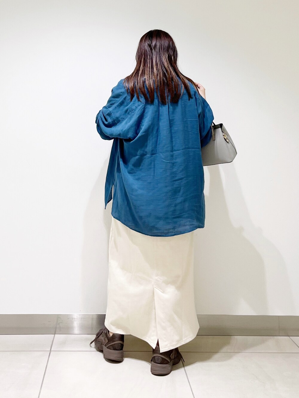 ブルー系のシャツ/ブラウス、ベージュ系のワンピース、グレー系のトートバッグを着用したレディースの夏コーディネートの6枚目の写真