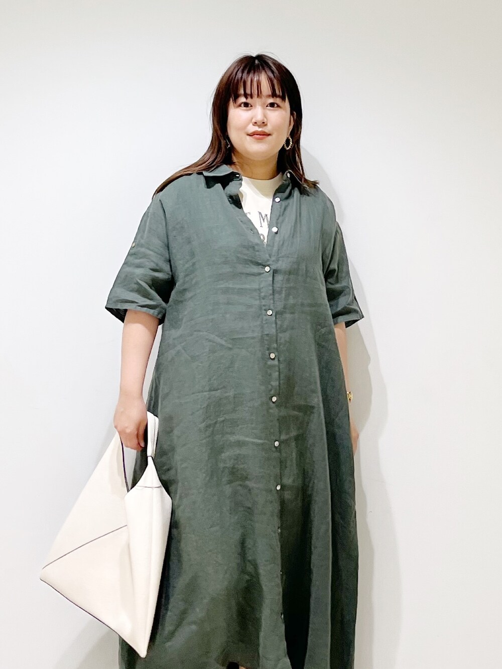 グリーン系のワンピース、ホワイト系のトートバッグ、ベージュ系のサンダルを着用したレディースの春コーディネートの10枚目の写真