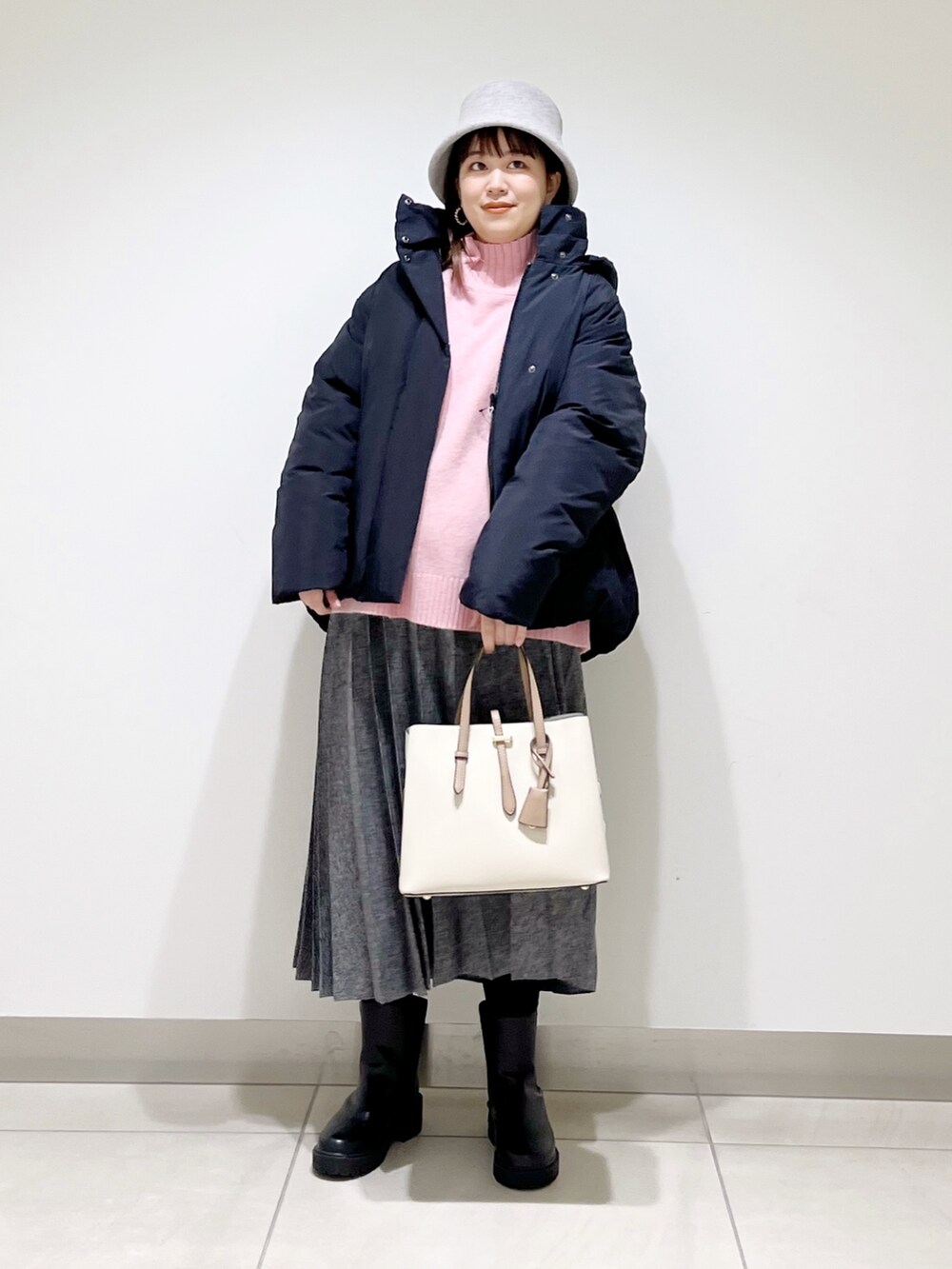 ブラック系のダウンジャケット/コート、ピンク系のニット/セーター、ブルー系のスカートを着用したレディースの冬コーディネートの8枚目の写真