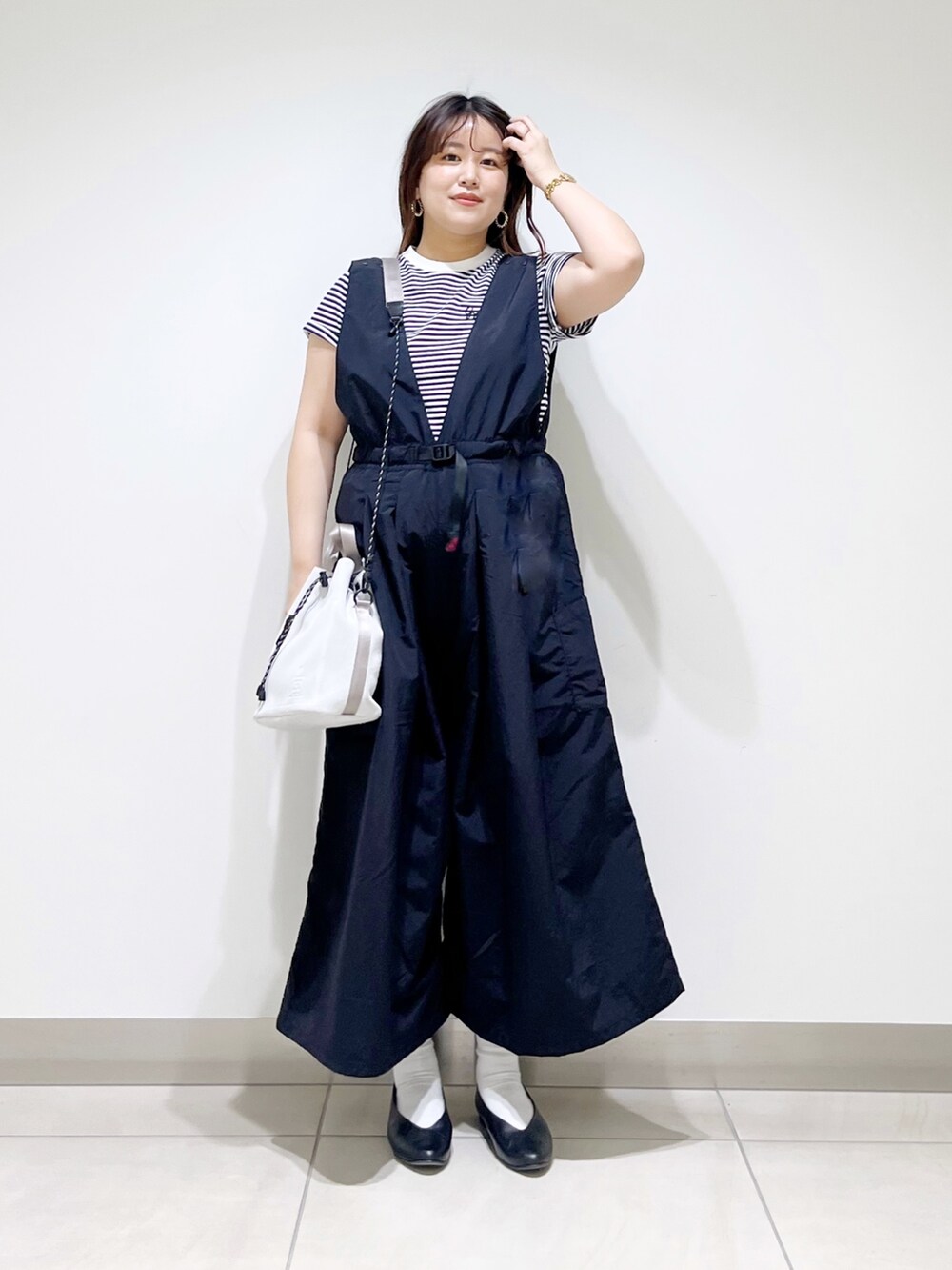 ブラック系のサロペット/オーバーオール、グレー系のTシャツ/カットソー、ホワイト系のショルダーバッグを着用したレディースの春コーディネートの5枚目の写真