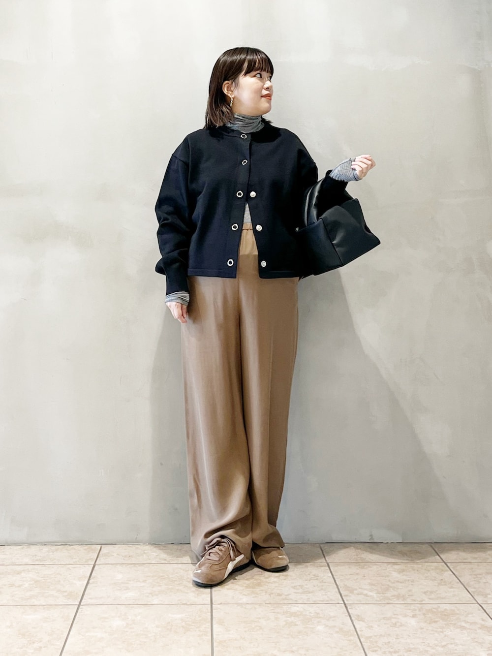 ブラック系のカーディガン/ボレロ、ベージュ系のその他パンツ、ブラック系のバッグを着用したレディースの秋コーディネートの6枚目の写真