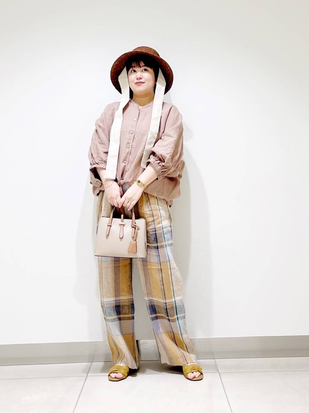 ベージュ系のハンドバッグ、イエロー系のその他パンツ、イエロー系のサンダルを着用したレディースの春コーディネートの10枚目の写真