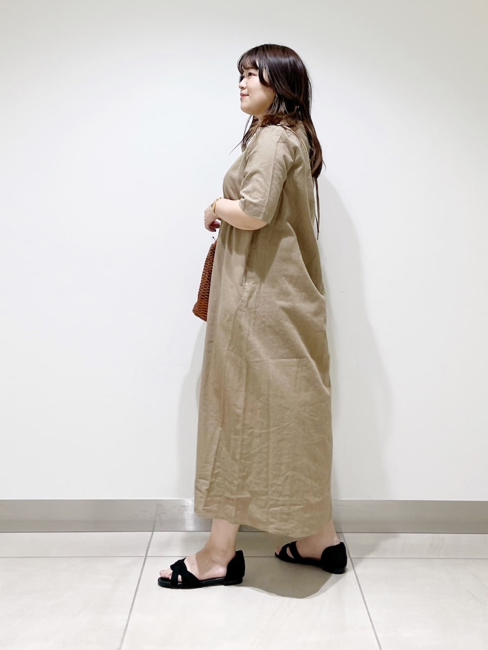 ベージュ系のワンピース、ブラウン系のショルダーバッグ、ブラック系のサンダルを着用したレディースの春コーディネートの6枚目の写真