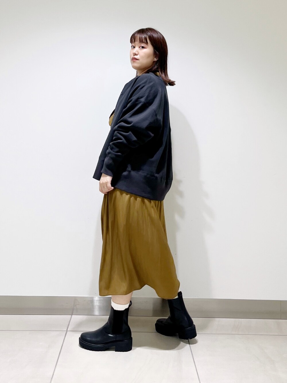 グリーン系のワンピース、その他のトップス、ブラック系のブーツを着用したレディースの秋コーディネートの8枚目の写真