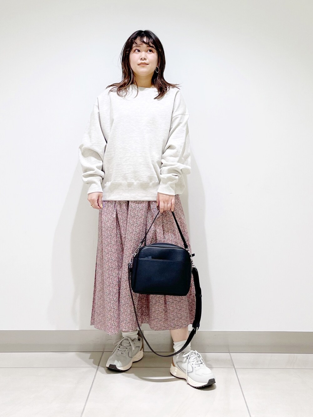 グレー系のスウェット、ピンク系のスカート、ブラック系のショルダーバッグを着用したレディースの春コーディネートの4枚目の写真