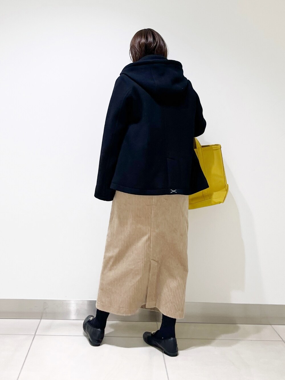 ブラック系のピーコート、ブルー系のニット/セーター、ブラック系のローファーを着用したレディースの冬コーディネートの3枚目の写真