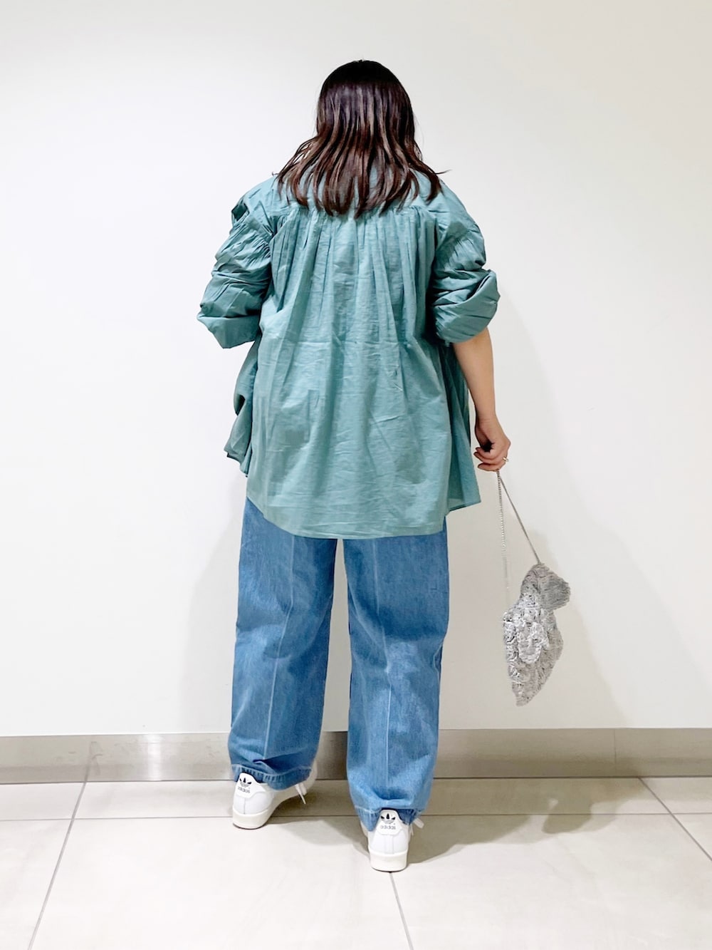 グリーン系のシャツ/ブラウス、ブルー系のデニムパンツ、シルバー系のバッグを着用したレディースの春コーディネートの5枚目の写真