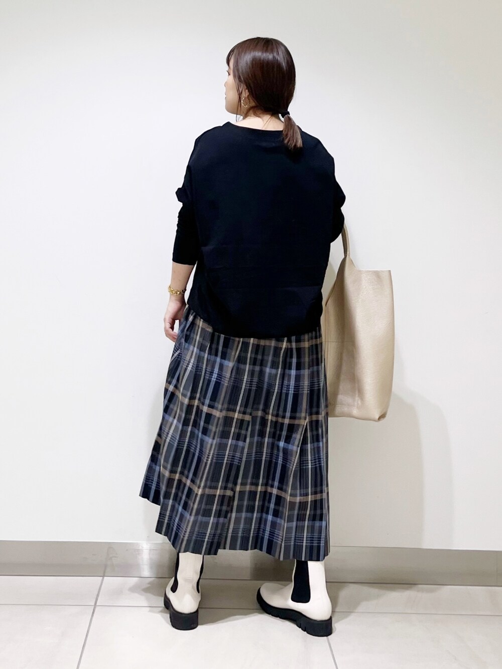 ブラック系のTシャツ/カットソー、ゴールド系のトートバッグ、ホワイト系のブーツを着用したレディースの秋コーディネートの6枚目の写真