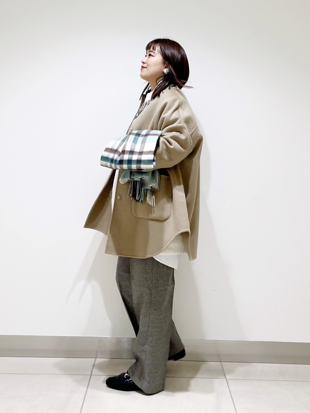 ベージュ系のノーカラージャケット、ホワイト系のニット/セーター、グレー系のその他パンツを着用したレディースの秋コーディネートの7枚目の写真