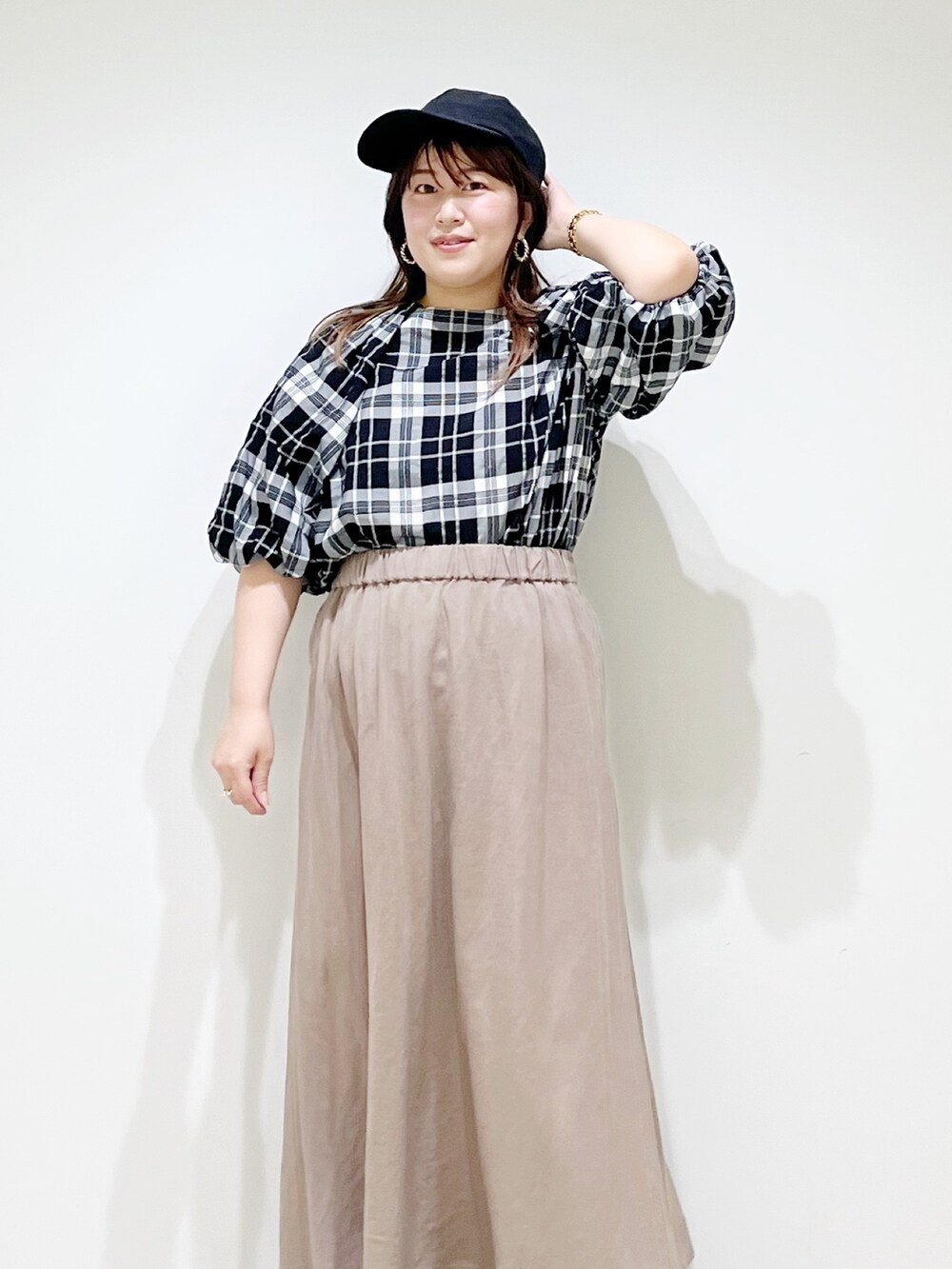 ベージュ系のスカート、ベージュ系のサンダル、ブラック系のシャツ/ブラウスを着用したレディースの夏コーディネートの5枚目の写真