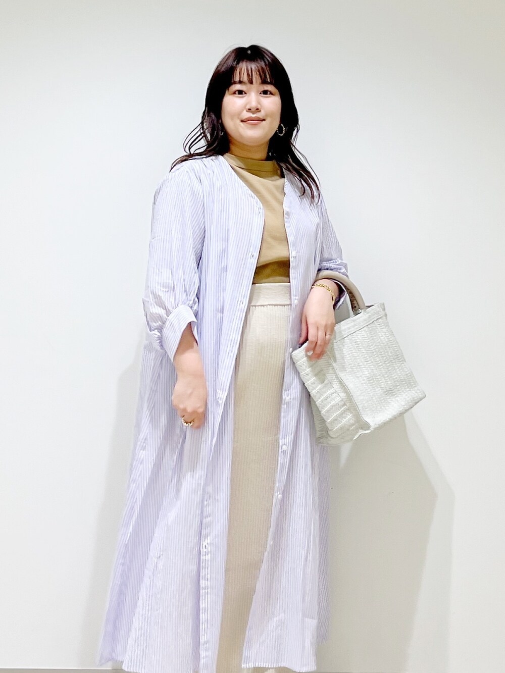 ベージュ系のTシャツ/カットソー、ベージュ系のスカート、パープル系のワンピースを着用したレディースの春コーディネートの9枚目の写真