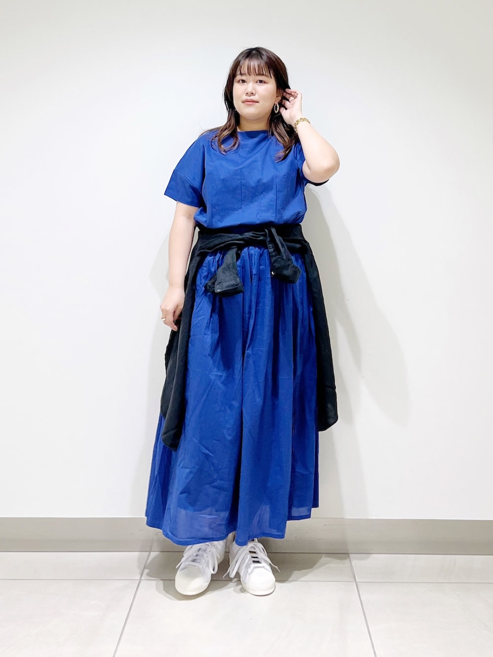 ブルー系のワンピース、ブラック系のシャツ/ブラウス、ホワイト系のスニーカーを着用したレディースの春コーディネートの7枚目の写真