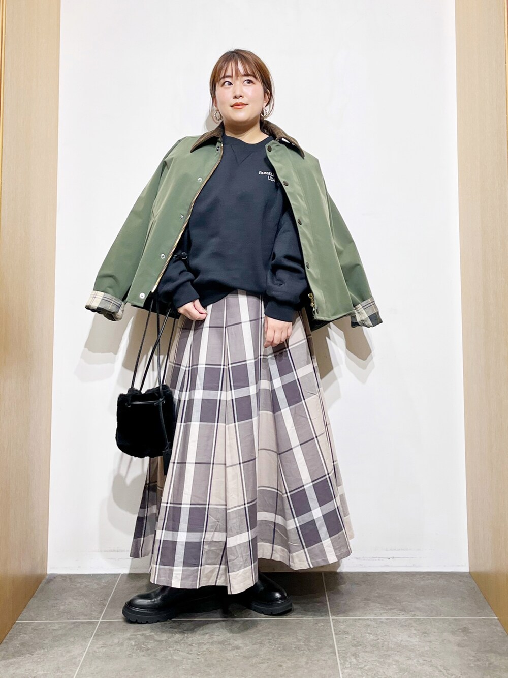 グリーン系のその他アウター、ブラック系のスウェット、ブラック系のハンドバッグを着用したレディースの冬コーディネートの4枚目の写真