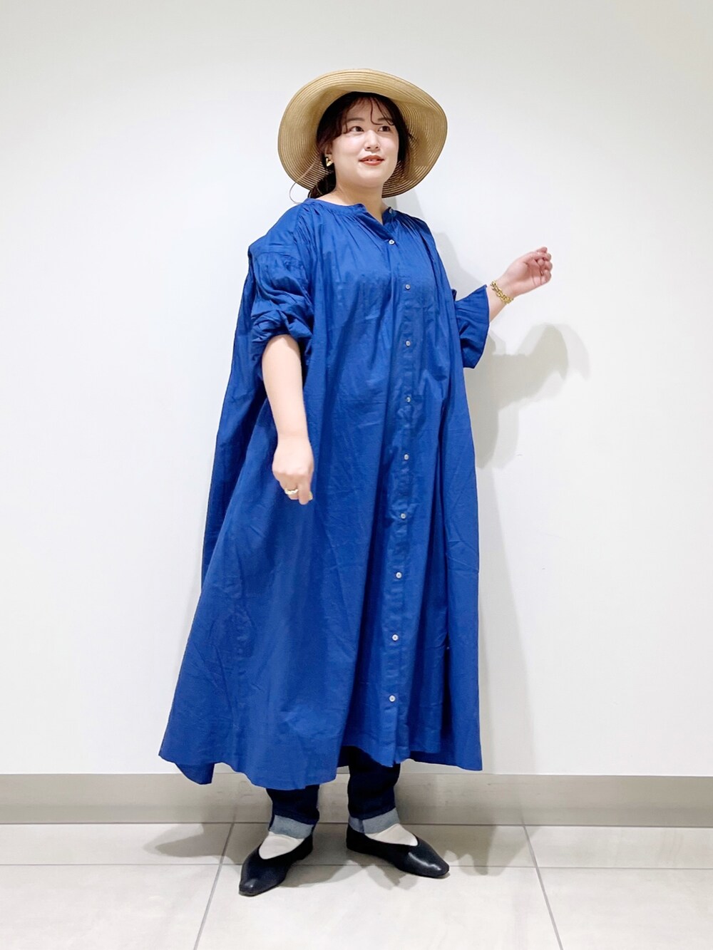 ブルー系のワンピース、ブルー系のデニムパンツ、ブラック系のバレエシューズを着用したレディースの春コーディネートの5枚目の写真