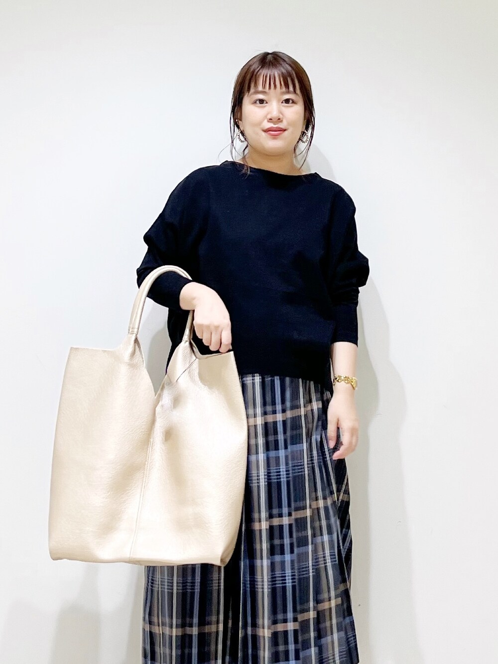 ブラック系のTシャツ/カットソー、ゴールド系のトートバッグ、ホワイト系のブーツを着用したレディースの秋コーディネートの4枚目の写真