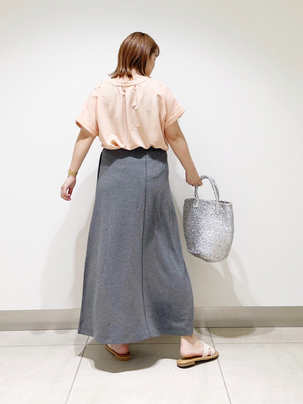 オレンジ系のシャツ/ブラウス、シルバー系のトートバッグ、グレー系のスカートを着用したレディースの春コーディネートの4枚目の写真