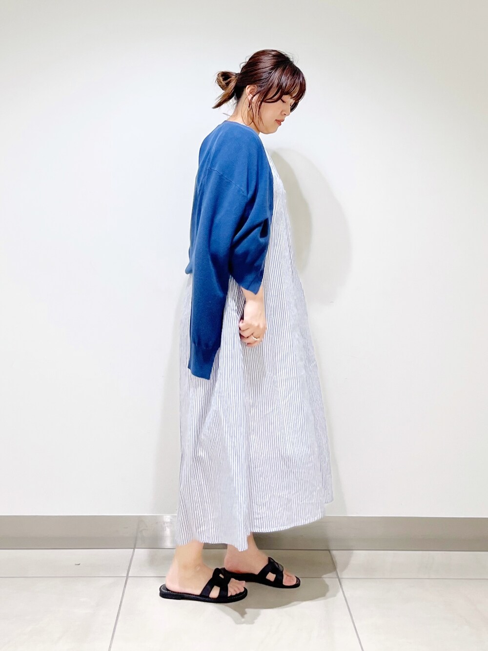 ブルー系のワンピース、ブルー系のニット/セーター、ブラック系のサンダルを着用したレディースの春コーディネートの6枚目の写真