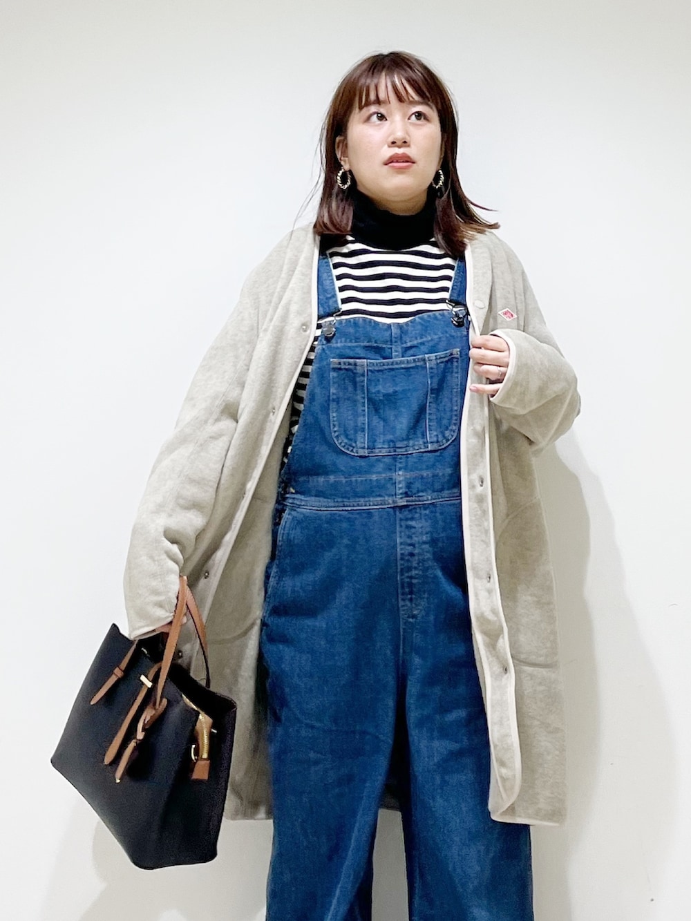 ブルー系のサロペット/オーバーオール、ベージュ系のジャケット/アウター、ブラック系のトップスを着用したレディースの秋コーディネートの5枚目の写真