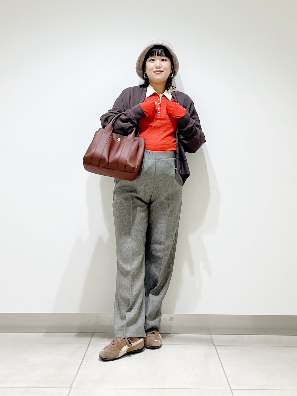 レッド系のニット/セーター、グレー系のその他パンツ、ブラック系のスニーカーを着用したレディースの秋コーディネートの10枚目の写真