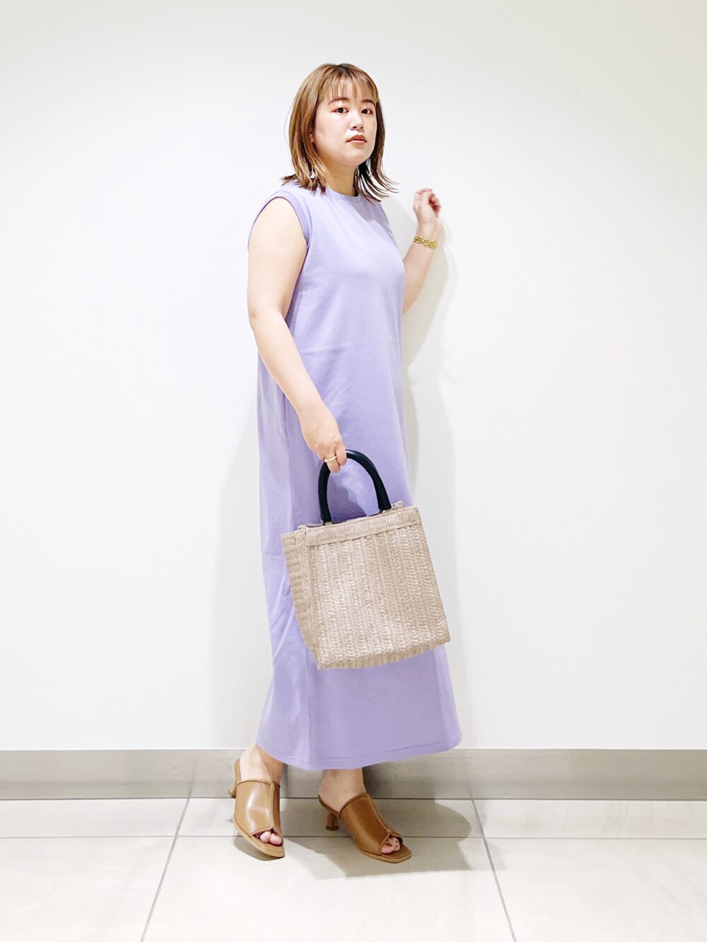 パープル系のワンピース、ベージュ系のトートバッグ、ベージュ系のサンダルを着用したレディースの夏コーディネートの3枚目の写真
