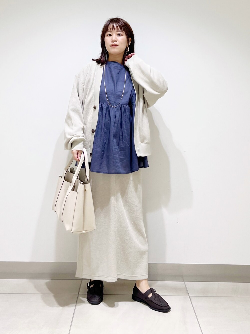 ブルー系のシャツ/ブラウス、ベージュ系のカーディガン/ボレロ、ベージュ系のスカートを着用したレディースの夏コーディネートの2枚目の写真