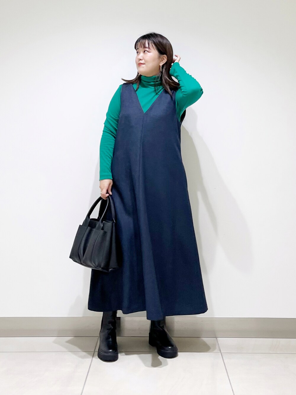 ブルー系のワンピース、ブラック系のトートバッグ、ブラック系のブーツを着用したレディースの秋コーディネートの2枚目の写真