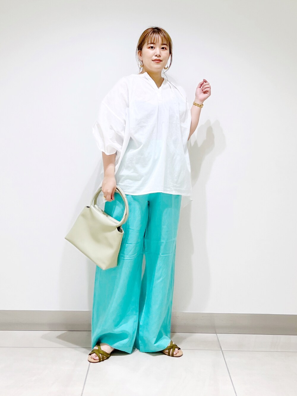 ホワイト系のシャツ/ブラウス、グリーン系のハンドバッグ、ブルー系のその他パンツを着用したレディースの夏コーディネートの5枚目の写真