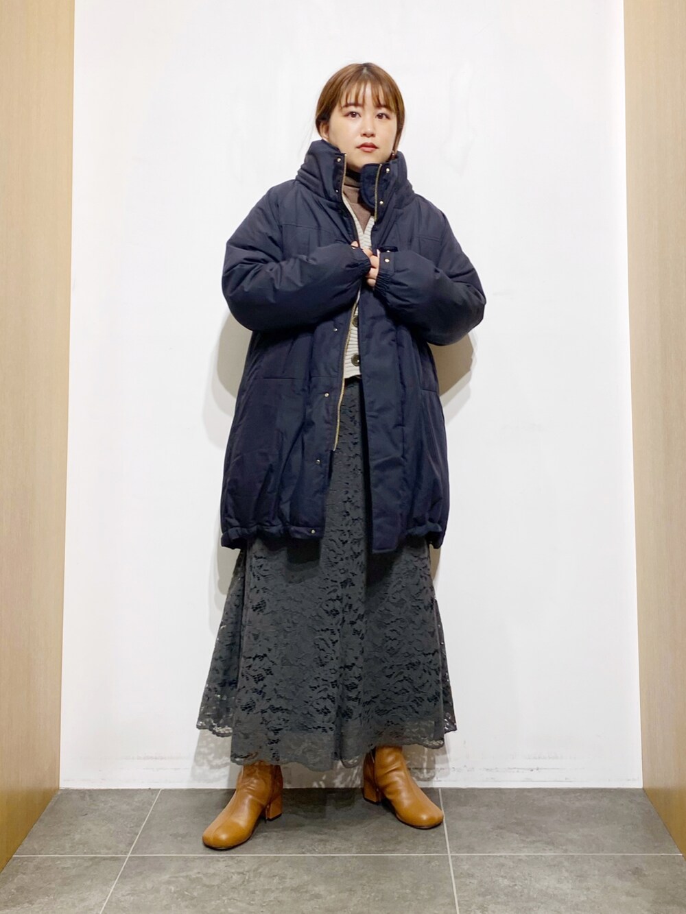 ブラック系のダウンジャケット/コート、ホワイト系のカーディガン/ボレロ、ブラウン系のTシャツ/カットソーを着用したレディースの秋コーディネートの3枚目の写真