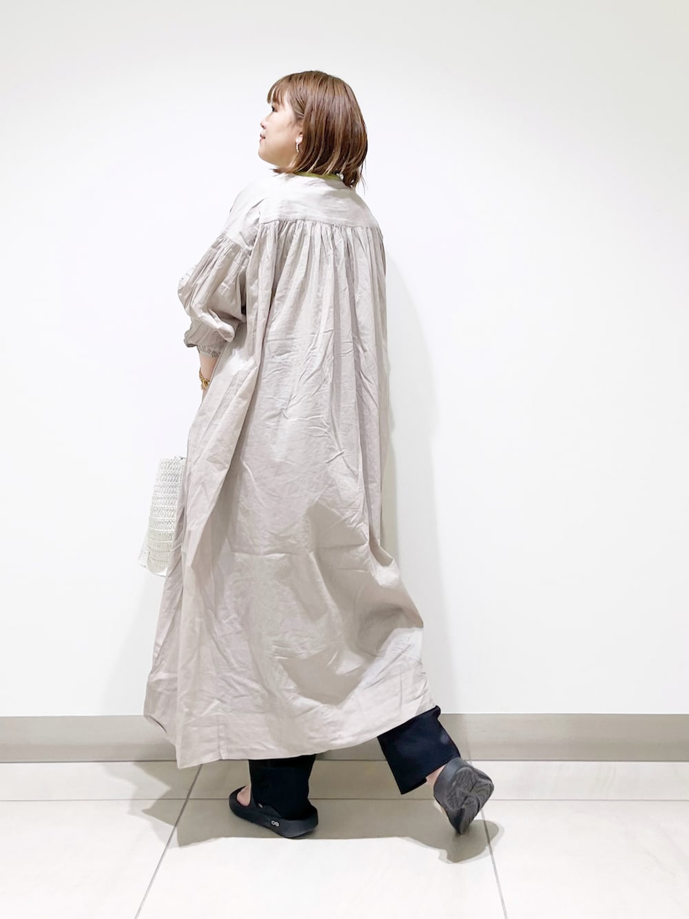 グレー系のワンピース、ホワイト系のトートバッグ、グリーン系のTシャツ/カットソーを着用したレディースの春コーディネートの5枚目の写真