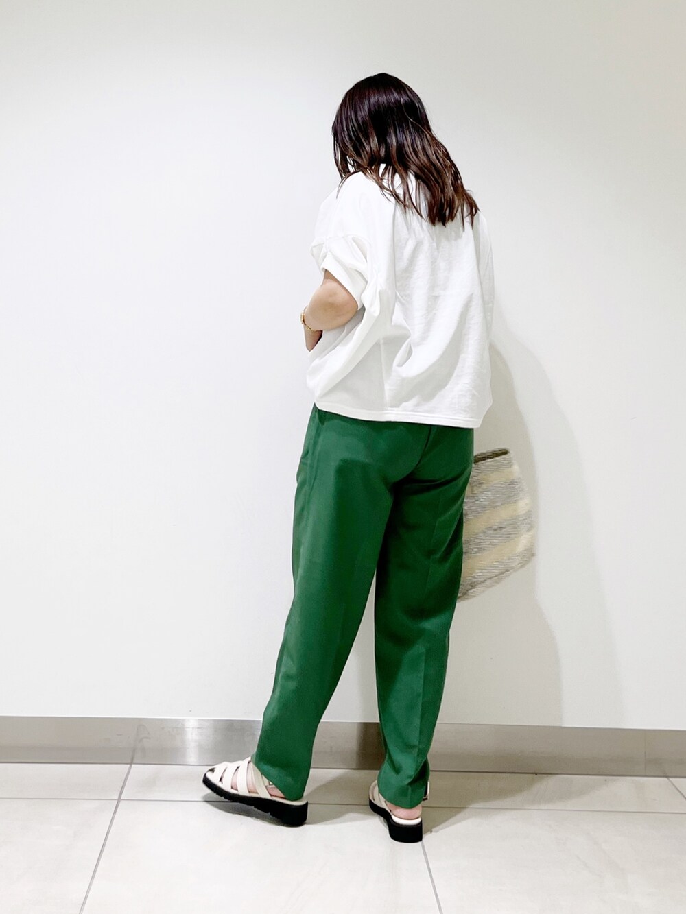 グリーン系のその他パンツ、ホワイト系のTシャツ/カットソー、ホワイト系のハンドバッグを着用したレディースの春コーディネートの5枚目の写真