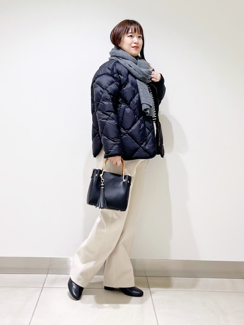 ブラック系のTシャツ/カットソー、ブラック系のダウンジャケット/コート、ブラック系のトートバッグを着用したレディースの秋コーディネートの2枚目の写真