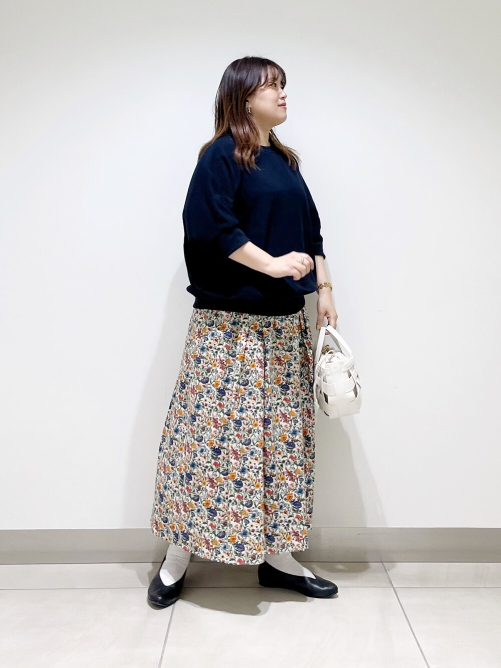 ブルー系のTシャツ/カットソー、ホワイト系のスカート、ホワイト系のショルダーバッグを着用したレディースの春コーディネートの4枚目の写真