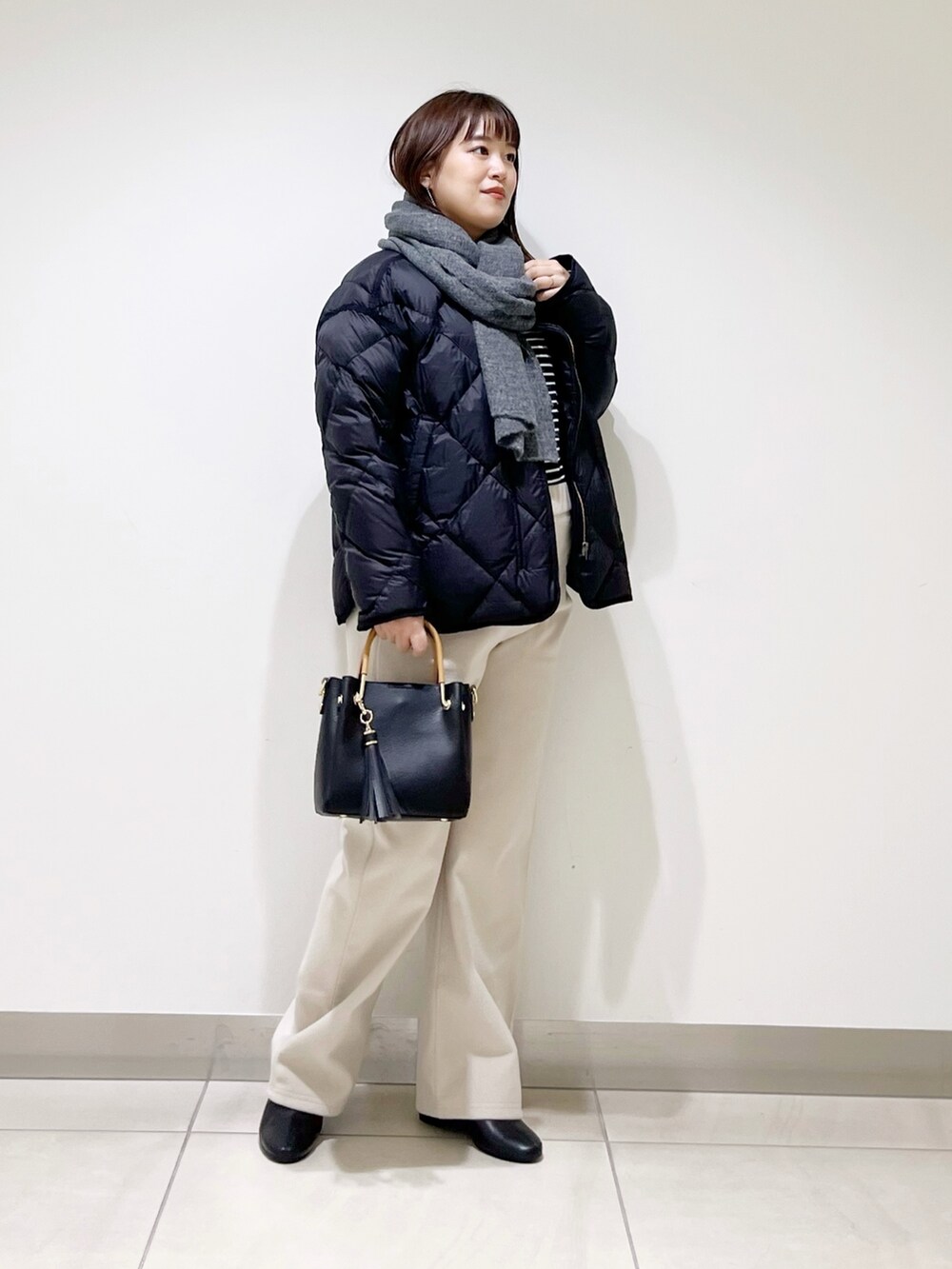 ブラック系のTシャツ/カットソー、ブラック系のダウンジャケット/コート、ブラック系のトートバッグを着用したレディースの秋コーディネートの5枚目の写真