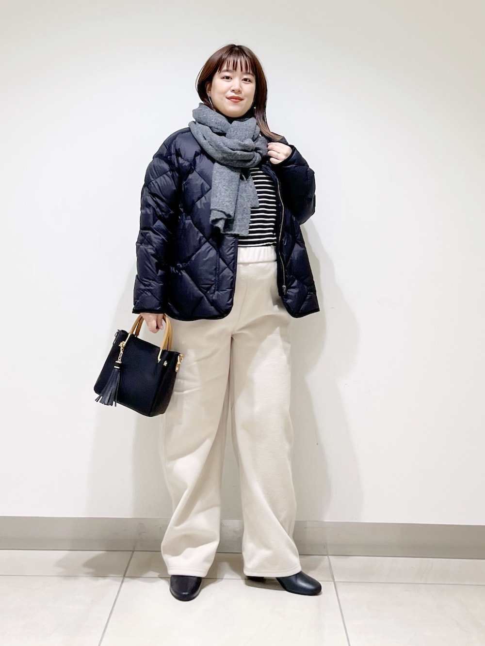 ブラック系のTシャツ/カットソー、ブラック系のダウンジャケット/コート、ブラック系のトートバッグを着用したレディースの秋コーディネートの3枚目の写真