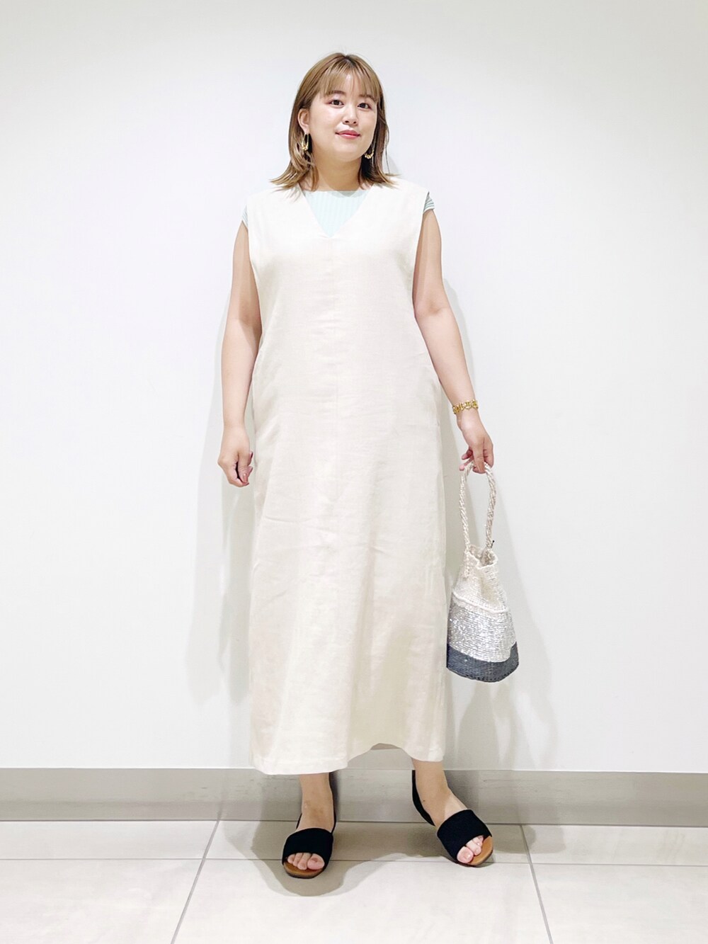 ベージュ系のワンピース、その他のハンドバッグ、ブラック系のサンダルを着用したレディースの夏コーディネートの4枚目の写真