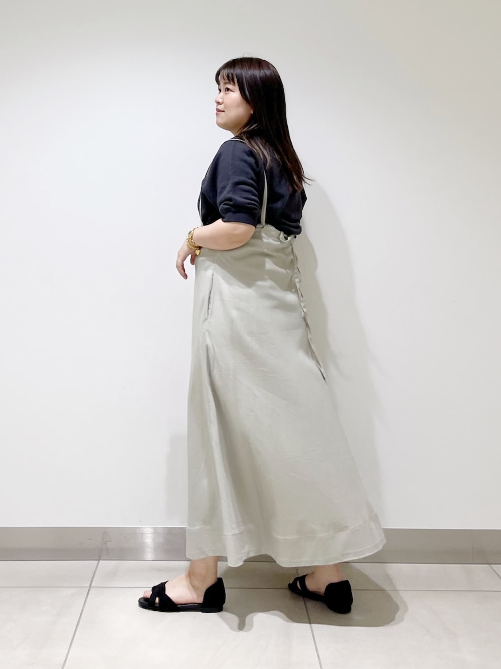 グレー系のTシャツ/カットソー、ベージュ系のスカート、シルバー系のショルダーバッグを着用したレディースの春コーディネートの4枚目の写真