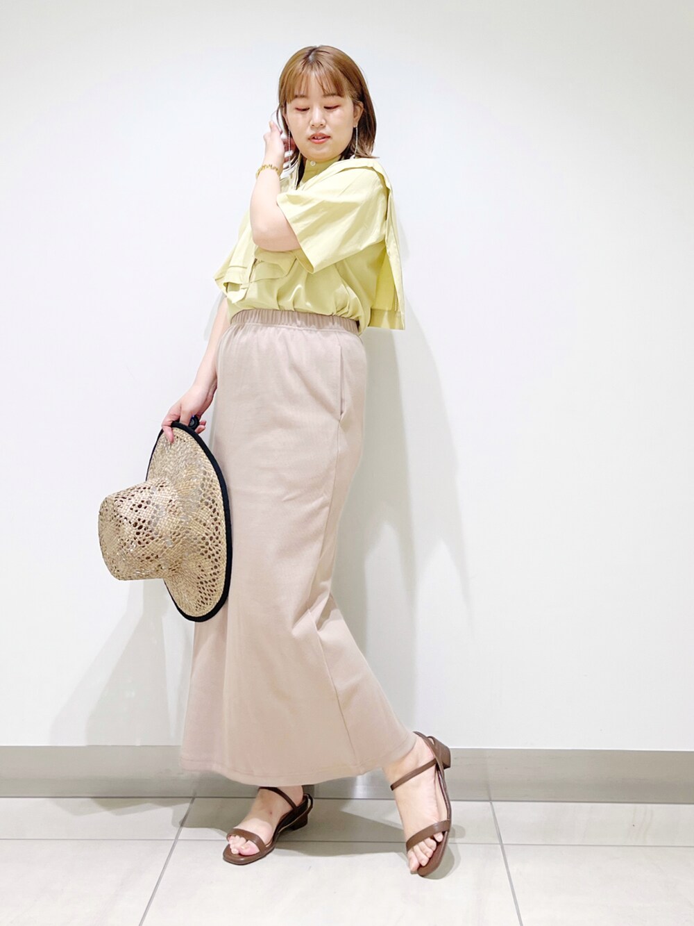 イエロー系のシャツ/ブラウス、ブラウン系のサンダル、ベージュ系のスカートを着用したレディースの夏コーディネートの4枚目の写真