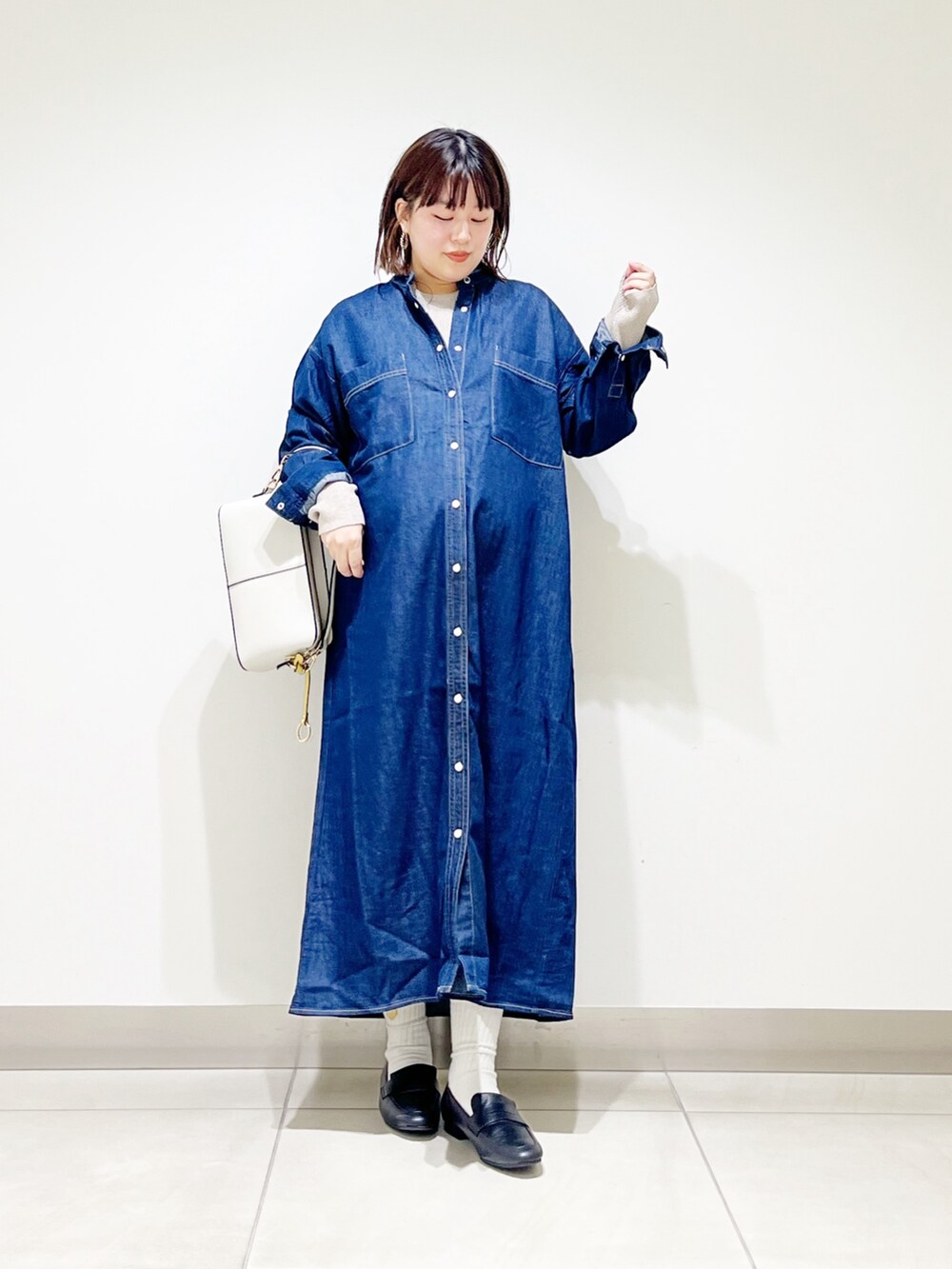 ブルー系のワンピース、ベージュ系のニット/セーター、ホワイト系のショルダーバッグを着用したレディースの秋コーディネートの8枚目の写真