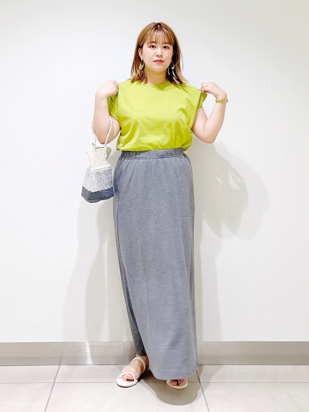 グリーン系のTシャツ/カットソー、グレー系のスカート、その他のハンドバッグを着用したレディースの夏コーディネートの2枚目の写真