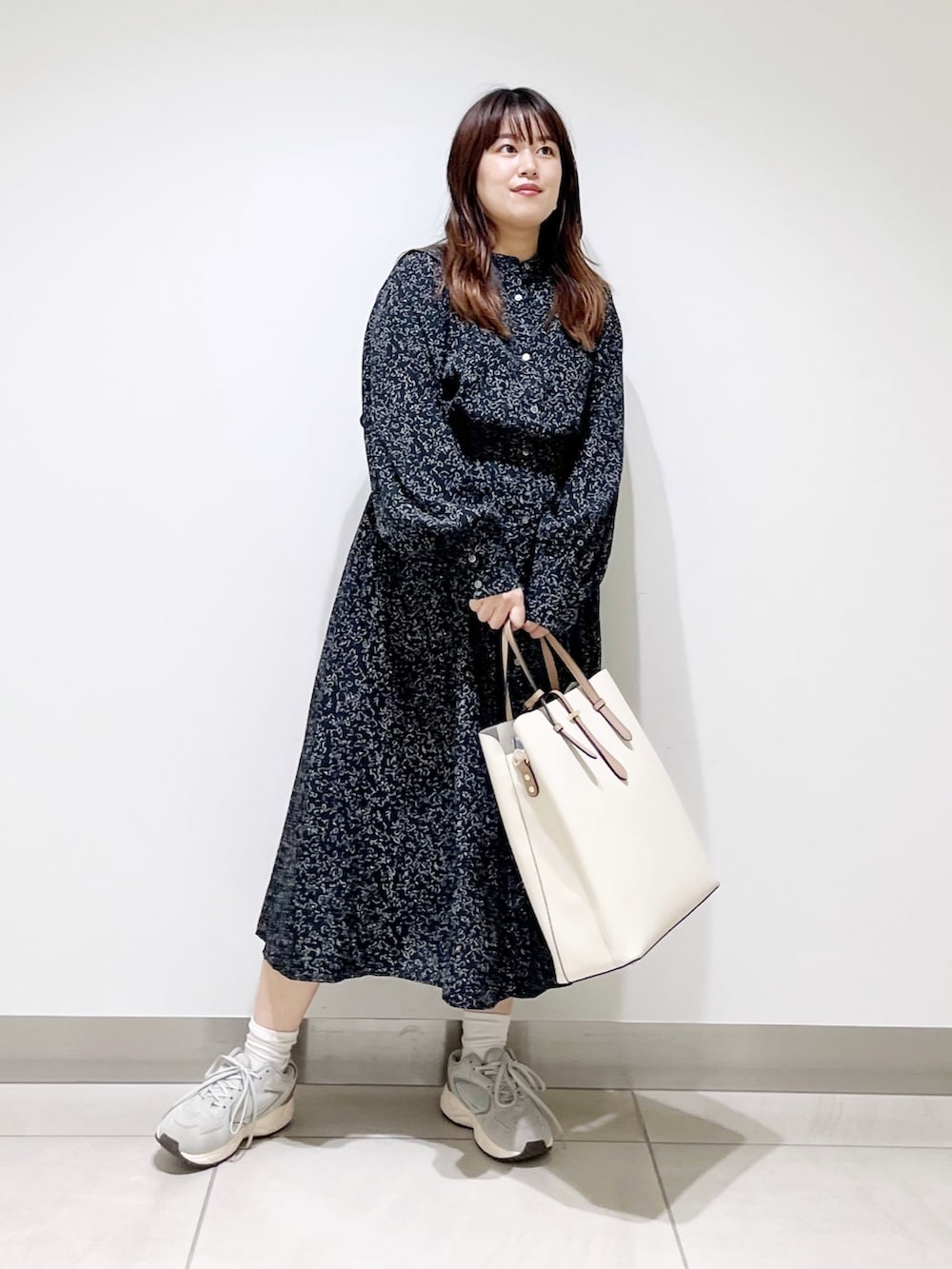 ブラック系のワンピース、ホワイト系のトートバッグ、グレー系のスニーカーを着用したレディースの夏コーディネートの4枚目の写真