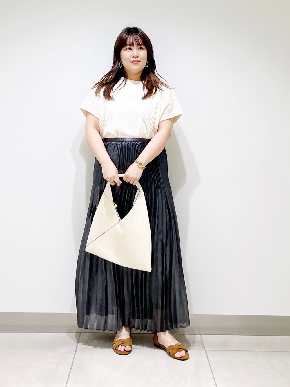 ホワイト系のニット/セーター、ホワイト系のトートバッグ、ブラック系のスカートを着用したレディースの夏コーディネートの4枚目の写真