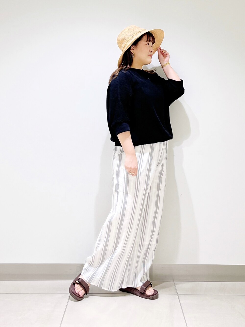 ブラック系のTシャツ/カットソー、ホワイト系のその他パンツ、ブラウン系のサンダルを着用したレディースの春コーディネートの3枚目の写真