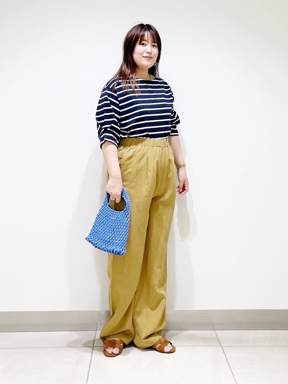 ホワイト系のTシャツ/カットソー、イエロー系のその他パンツ、ブルー系のハンドバッグを着用したレディースの夏コーディネートの2枚目の写真