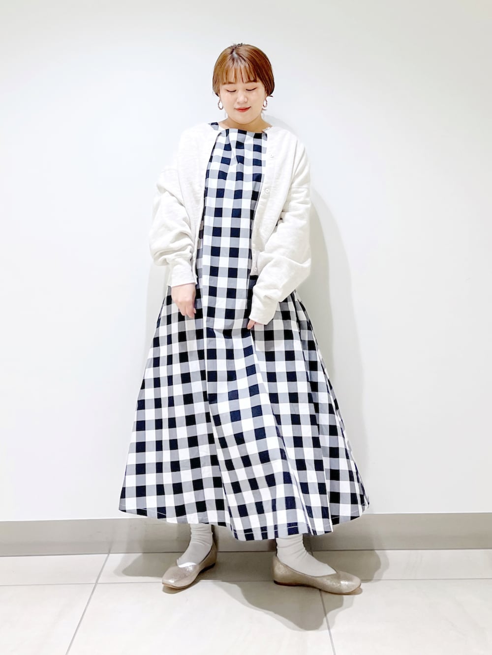 ブラック系のワンピース、グレー系のカーディガン/ボレロ、ゴールド系のパンプスを着用したレディースの春コーディネートの3枚目の写真