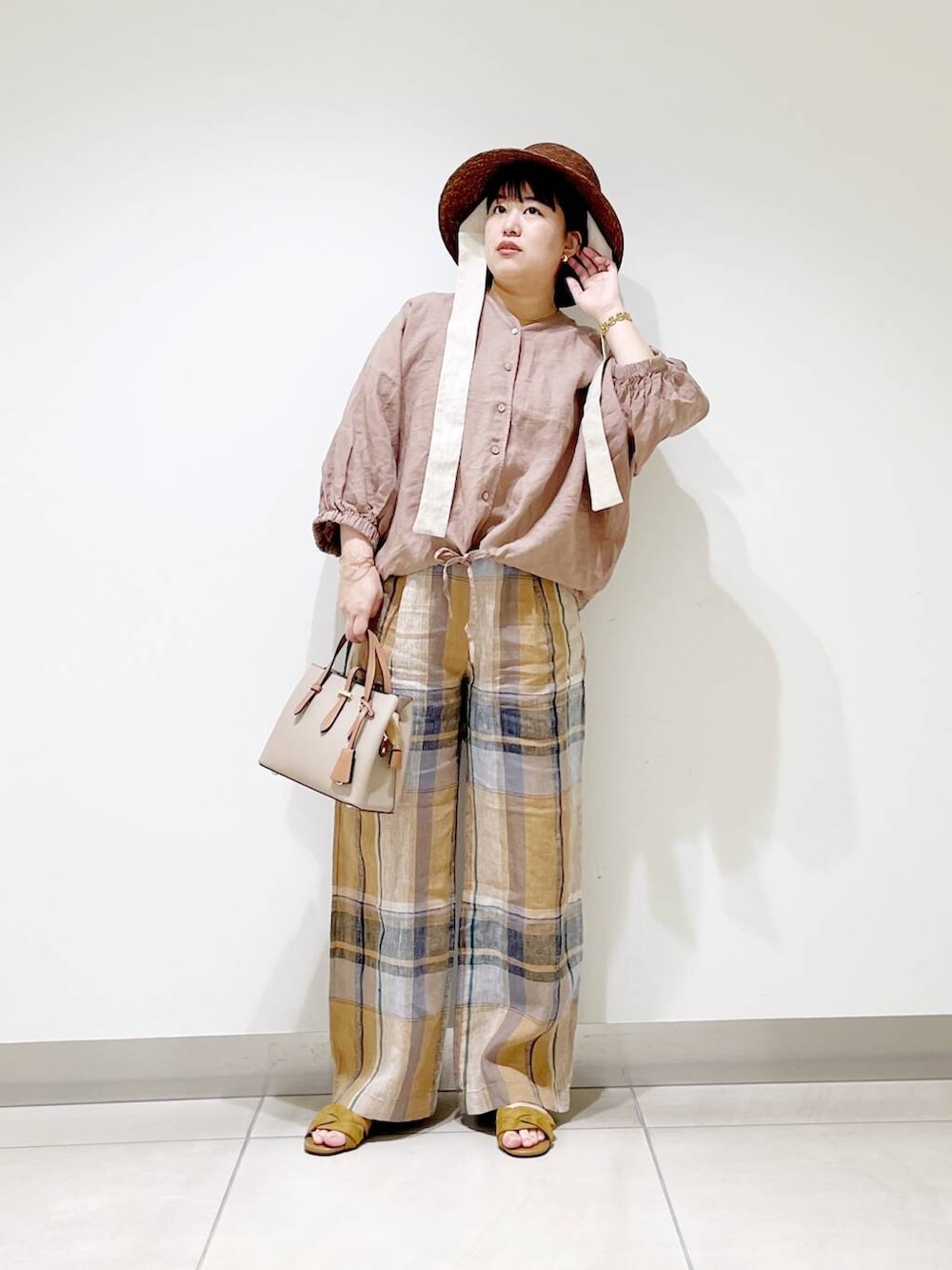 ベージュ系のハンドバッグ、イエロー系のその他パンツ、イエロー系のサンダルを着用したレディースの春コーディネートの4枚目の写真